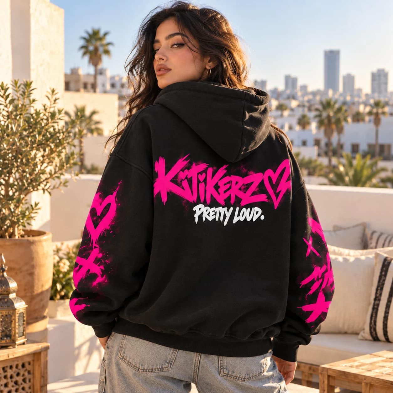 Hoodie KITIKERZ porté de dos en journée : logo Electric Pink et signature PRETTY LOUD. blanche.